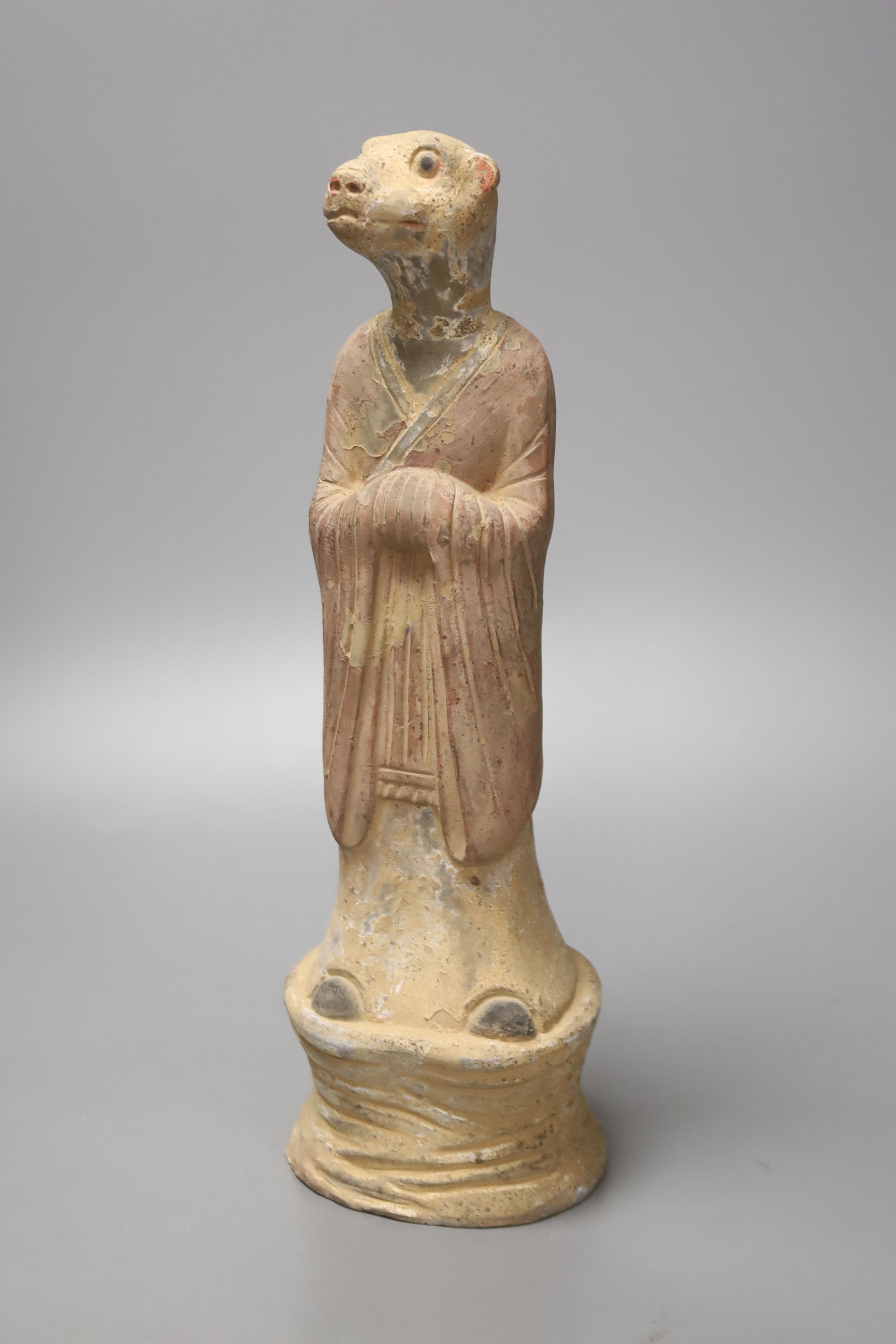 A Chinese tomb pottery zodiac figure of a dog, Han dynasty or later, 28cm high